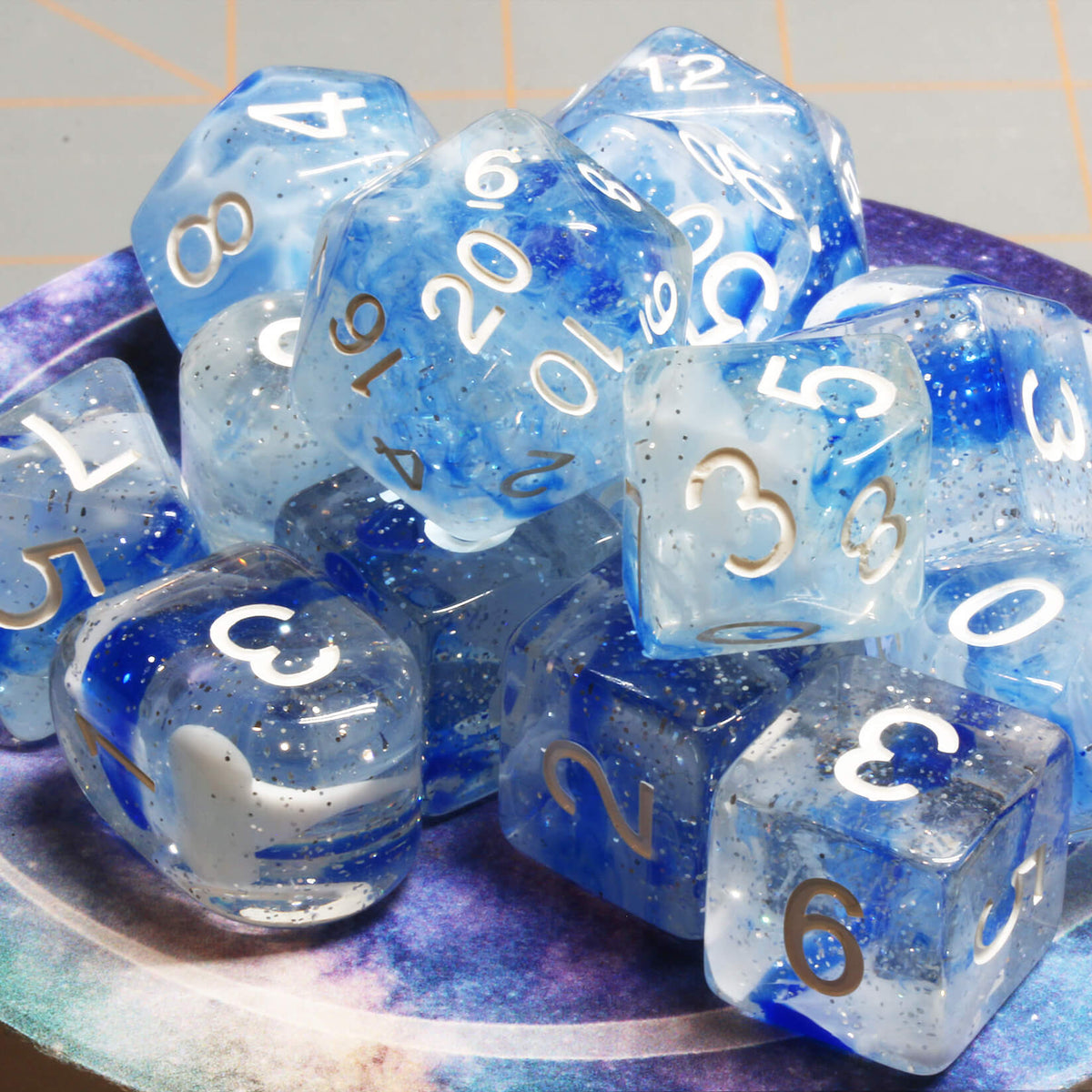 Translucent blue and white swirled polyhedral dice with white numbers, including a D20, for Dungeons & Dragons and other tabletop RPGs.
