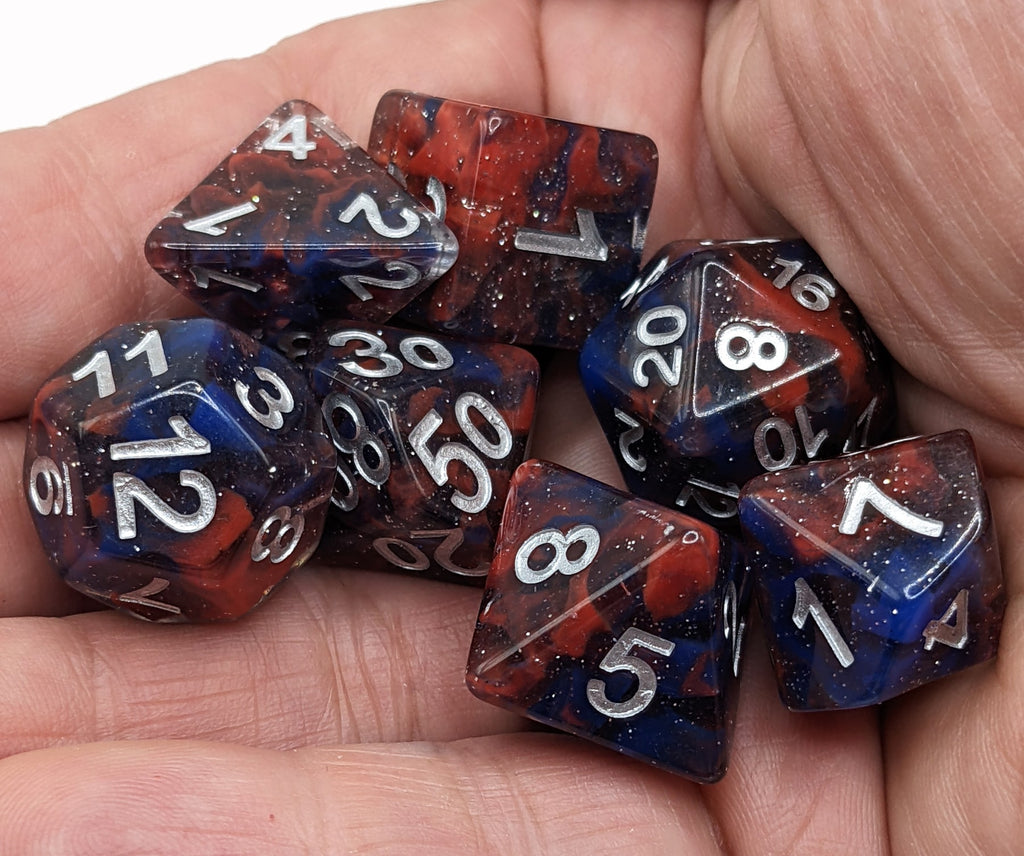 Celestial Dice Red and Blue held in the hand and ready to roll