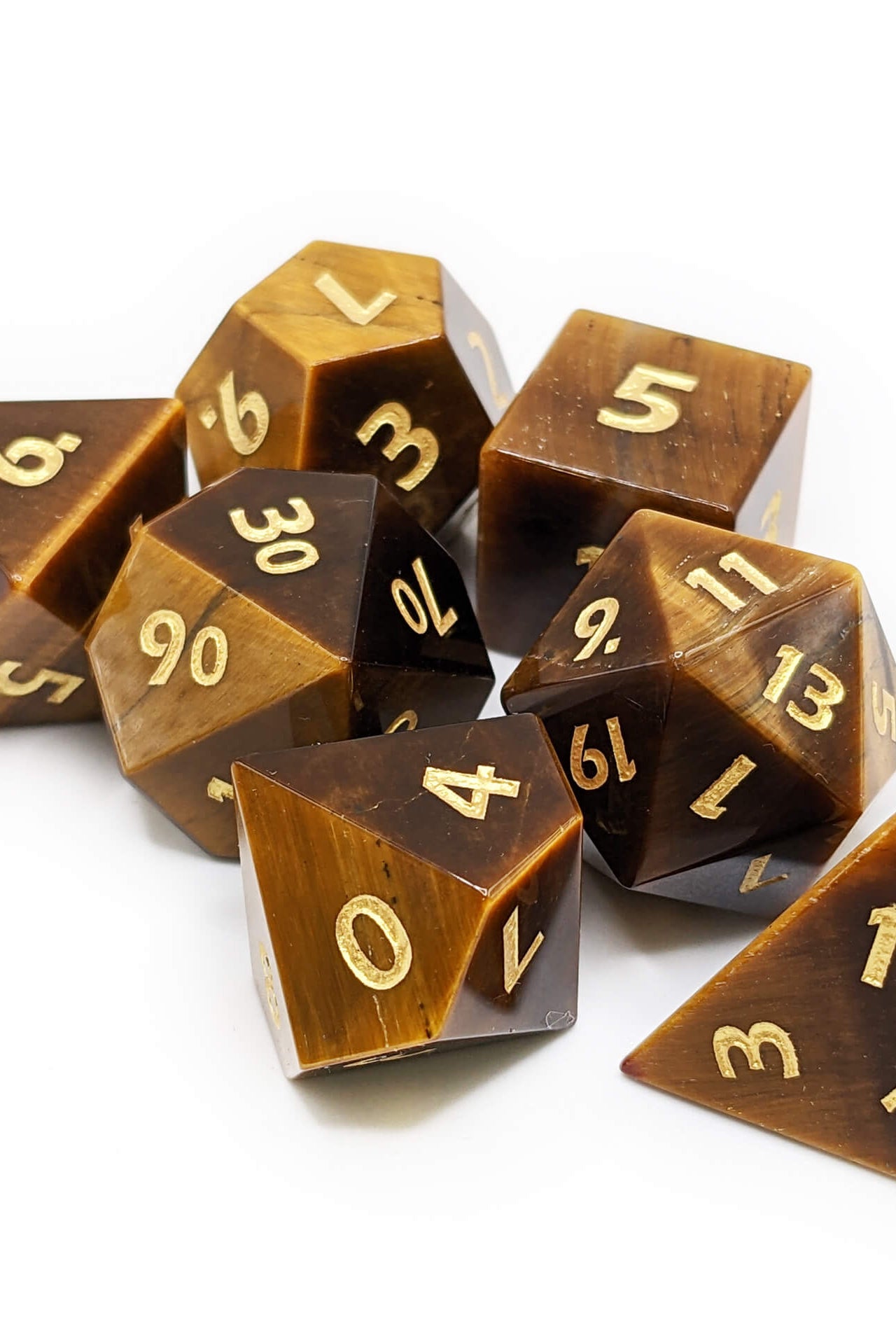Stone tigers eye dice with gold numbers